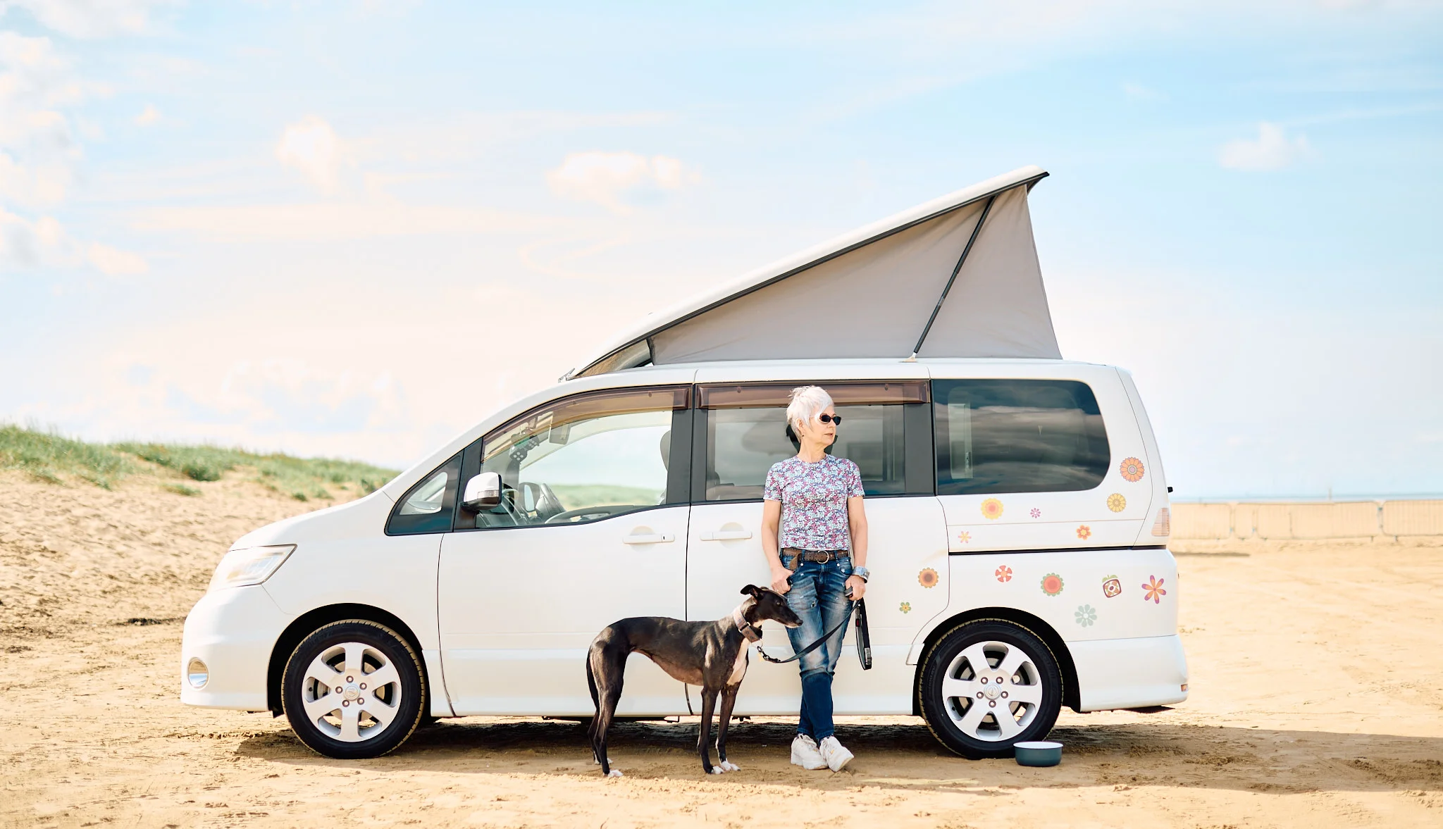 leaning against camper van on the beach